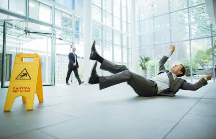Businessman Slipping On Floor Of Office Building And Looking For Personal Injury Attorney